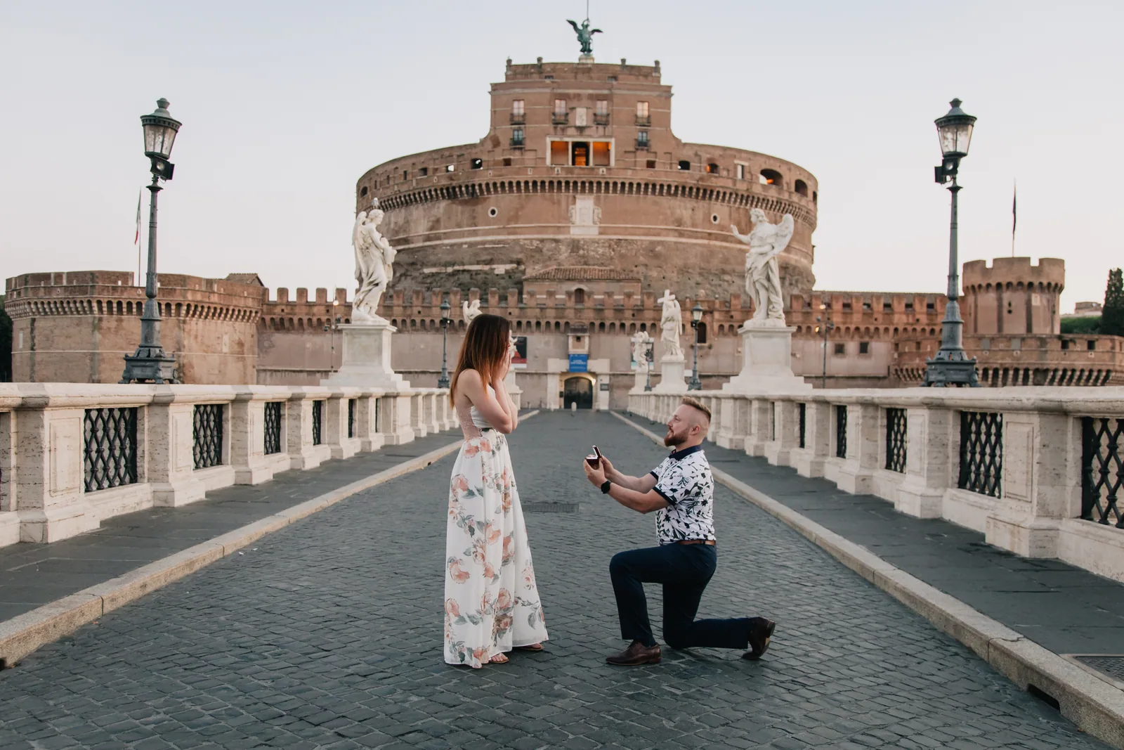 Patrick demandant Catherine en mariage à l’aube, sur le Ponte Sant’Angelo à Rome